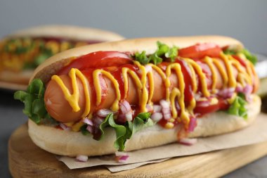 Soslu, marullu, soğanlı ve domatesli lezzetli sosisli, yakın plan.