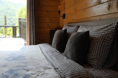 Otel odasının penceresinin yanında rahat bir yatak.