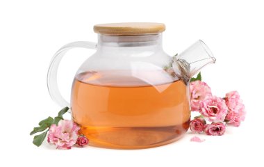 Cam çaydanlıkta leziz bir gül çayı, beyazın üzerinde izole edilmiş çiçekler ve yapraklar.