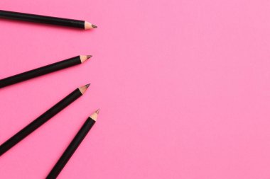 Farklı kaş kalemleri parlak pembe arka planda, düz yerde. Metin için boşluk