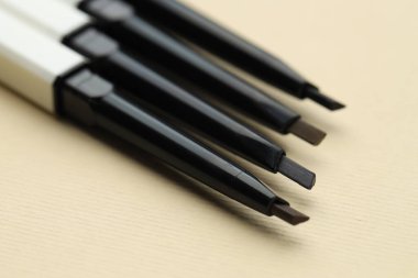 Bej arka planda otomatik kaş kalemleri, makro görünüm