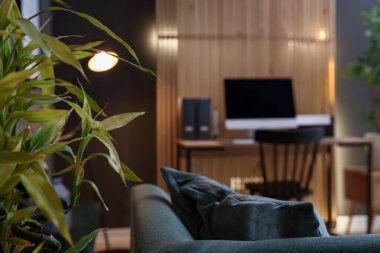 Ahşap masalı, bilgisayarlı, kapalı mekanlı, seçici odaklı şık bir iş yeri.