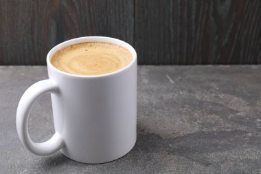 Koyu ahşap arka planda gri desenli fincanda koyu kahve, yakın plan. Metin için boşluk