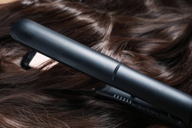 Modern düz ütü, parlak kahverengi saçlar, yakın plan.