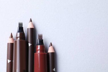 Beyaz arka planda farklı kaş kalemleri, düz yatış. Metin için boşluk