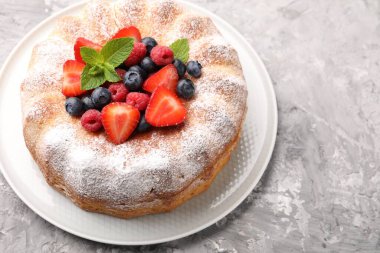 Gri desenli masada pudra şekeri ve böğürtlenli Lezzetli kek, yakın plan. Metin için boşluk