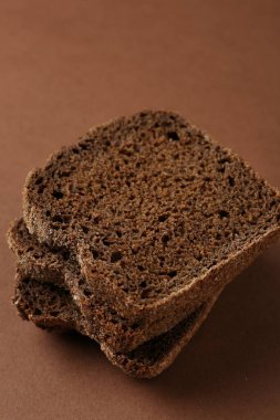 Kahverengi arka planda taze çavdar ekmeği parçaları, yakın plan.