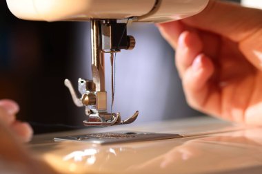 Bulanık gri arkaplanda dikiş makinesi iğnesi, makro görünümü olan kadın