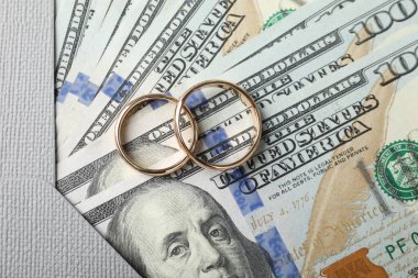 İki altın alyans, bir dolarlık banknotlar ve zarf.