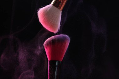 Siyah arkaplanda renkli göz gölgeli makyaj fırçaları, yakın plan