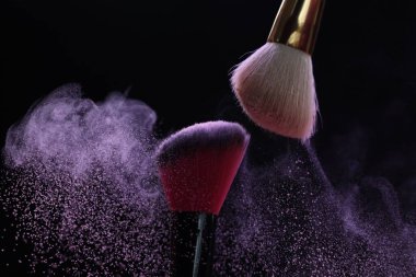 Siyah arka planda mor göz farlı makyaj fırçaları, yakın plan