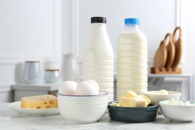 Beyaz mermer masa üzerinde farklı süt ürünleri ve yumurtalar.