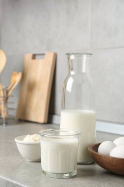 Mutfaktaki gri desenli masada farklı süt ürünleri ve yumurtalar.