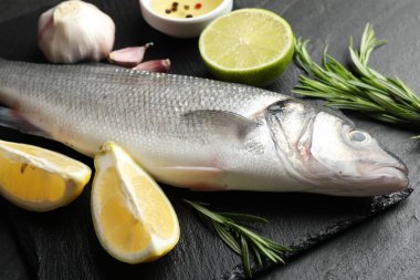 Siyah masada baharatlı taze çiğ deniz kabuğu, yakın plan. Balık ve deniz ürünleri lezzetleri