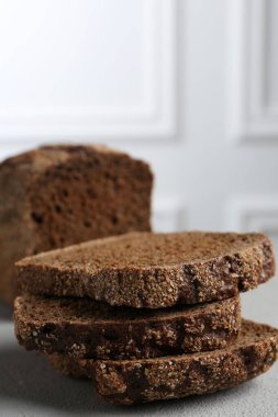 Açık gri desenli masada taze çavdar ekmeği parçaları, yakın plan.