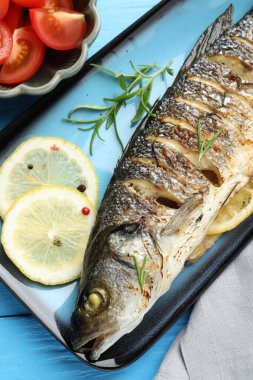 Baharatlı ve domatesli kızarmış deniz kabuğu balığı açık mavi ahşap masa, düz. Ev yapımı deniz ürünleri yemeği.