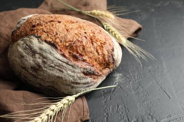 Siyah masaya bir somun taze ekmek ve çiviler, yakın plan. Metin için boşluk