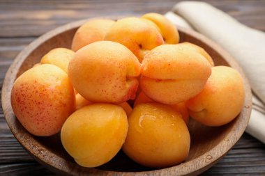 Tahta masadaki kasede taze kayısılar, yakın plan.