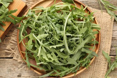 Taze yeşil roka yaprakları ahşap masanın üzerinde, düz yatıyordu.