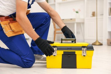 Kapalı mekanda alet çantası olan profesyonel bir tamirci.