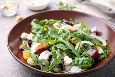 Lezzetli salata roka, peynir, şeftali, pancar ve fındık, yakın plan.