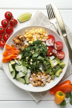 Beyaz ahşap masada servis edilen farklı sağlıklı vejetaryen yemekleri.