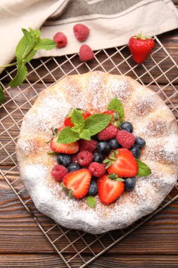 Tahta masada pudra şekeri ve böğürtlenli Lezzetli kek.