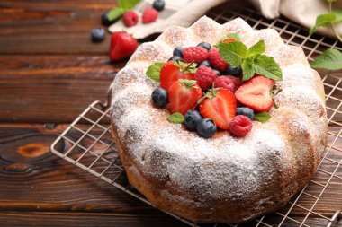 Ahşap masada pudra şekeri ve böğürtlenli Lezzetli kek, yakın plan. Metin için boşluk