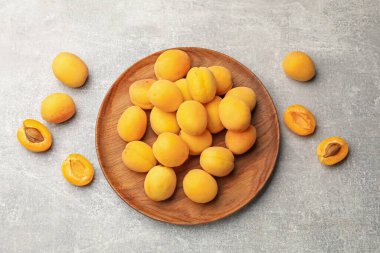 Taze olgun kayısılar gri masada, düz yatıyordu.