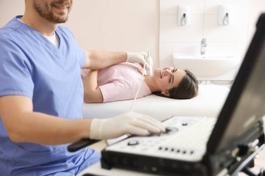 Sonograf klinikte kadının tiroid bezini ultrason taraması yapıyor.