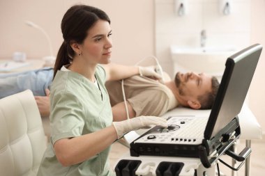 Sonograf klinikte tiroid bezini ultrasona sokuyor.