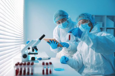 Tıbbi analiz. Laboratuvarda kan örneğiyle çalışan bilim adamları