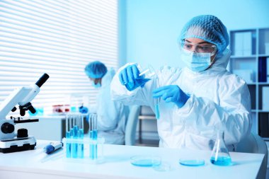 Tıbbi analiz. Laboratuvarda numuneyle çalışan bilim adamı, seçici odaklanma