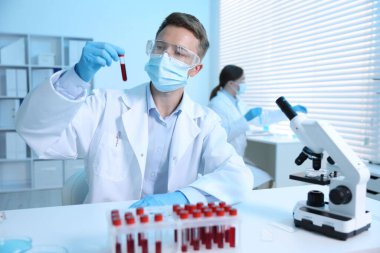 Tıbbi analiz. Laboratuvarda kan örneğiyle çalışan bir bilim adamı.