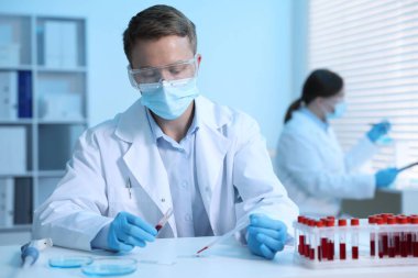 Tıbbi analiz. Laboratuvarda kan örneğiyle çalışan bir bilim adamı.