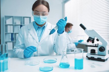 Tıbbi analiz. Laboratuvarda numuneyle çalışan bilim adamı, seçici odaklanma