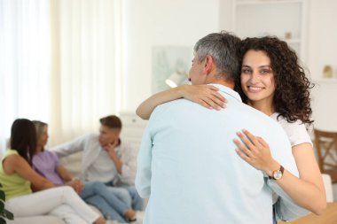 Mutlu arkadaşlar evde sarılıyor, seçici odaklanıyor.