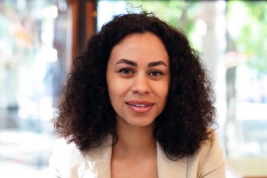 Kafedeki gülümseyen Latin Amerikalı kadının portresi.