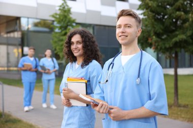 Dışarıda defterleri olan tıp öğrencileri, seçici bir odak noktası.