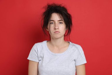 Kırmızı arka planda akşamdan kalma bir kadın.