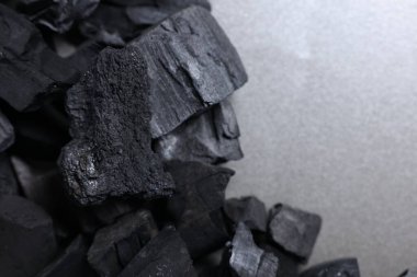 Gri masa üzerinde siyah kömür parçaları, üst manzara. Metin için boşluk