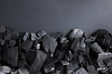 Gri arka planda siyah kömür parçaları, üst manzara. Metin için boşluk