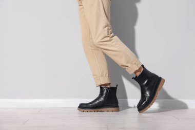 Kapalı mekanda bir çift bot giyen adam, yakın plan. Metin için boşluk