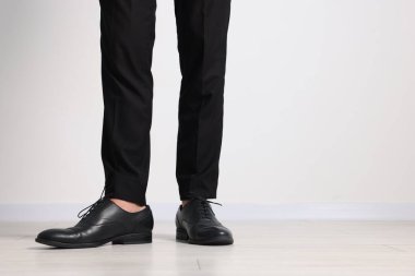 Kapalı mekanda siyah deri ayakkabı giyen bir adam, yakın plan. Metin için boşluk