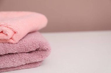 Beyaz masadaki renkli havlular yığını, yakın plan. Metin için boşluk