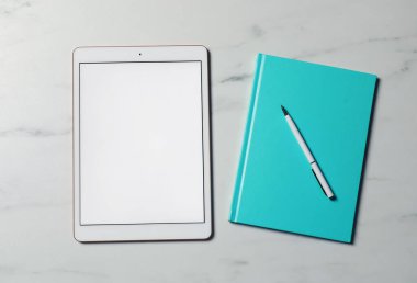 Tablet ve kırtasiye beyaz mermer masa, düz yatıyordu