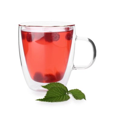 Cam bardakta Aromatik ahududu çayı ve beyaz bardakta yeşil yapraklar.