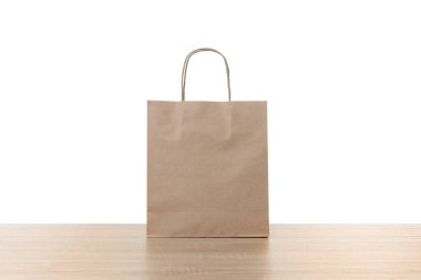 Tahta masada beyaz arkaplana karşı bir kese kağıdı.