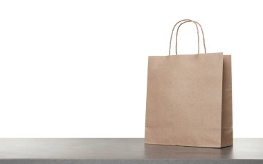 Beyaz arkaplana karşı gri masada bir kese kağıdı