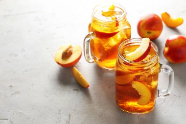 Masanın üstündeki kavanozlarda buzlu şeftali çayını tazeliyorum. Yakın plan. Metin için boşluk